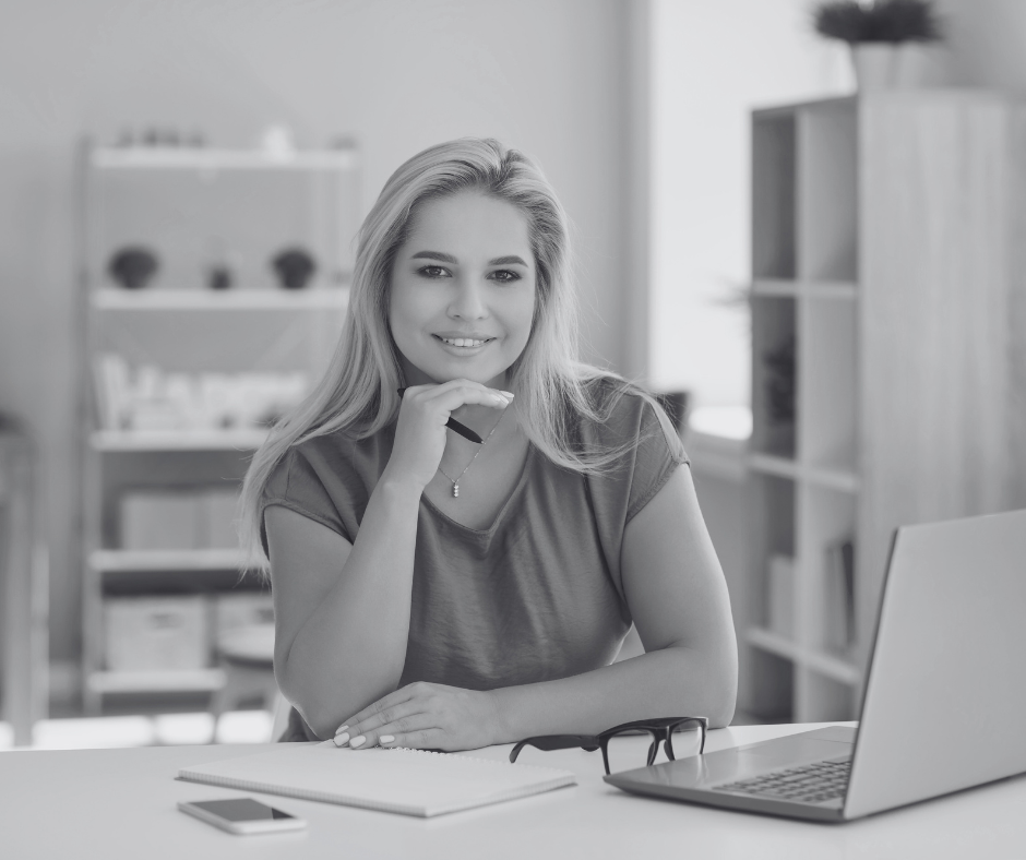 Smiling business woman looking thoughtful at her desk